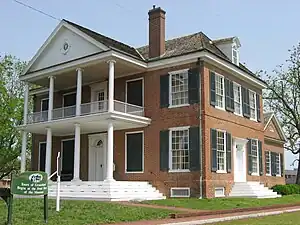 Large red brick home with two-story columned white porch