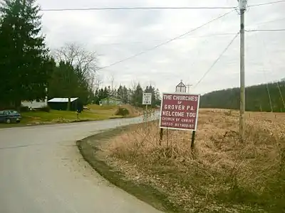 Sign for the churches of Grover, Pennsylvania as seen at a turn from State Route 154 in February 2012