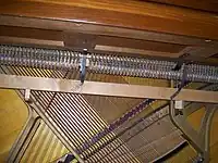 Detail of the interior structure of the Gulbransen spinet shown above. The drop action, lying below the level of the keyboard, can be seen, as well as the extreme angling of the strings needed to provide sufficient length of strings within the limited case height. Click on image for expanded view.