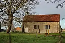 a small simple rectangular chapel with a red tiled roof