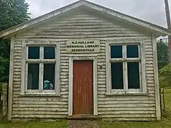 view of a rundown wooden library building