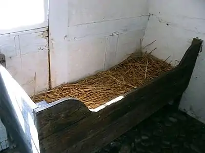 A similar wooden bed filled with straw, but without bedding, at a museum in Denmark