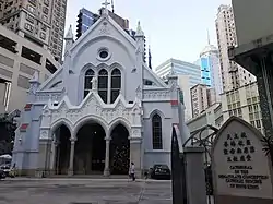 The facade of a gothic revival cathedral with flanking flying buttress on both sides