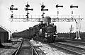 An NS 3600 behind NS 5554 with coaches under the signal gantry near Naarden-Bussum. (June 1936)