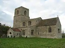 A stone church seen from the southeast, showing the chancel, beyond which is the nave with a clerestory, a south aisle and a porch, beyond which is a tower with a plain parapet