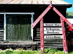 Welcome sign leaning against the goods shed of the Little River Railway Station.