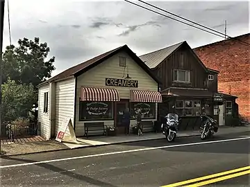 South wall of I.O.O.F. Building, at right; the former post office, at left, the sole structure surviving the 1917 fire (not included in historic district).