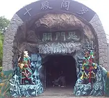 Entrance to the "Ten Courts of Hell"  attraction in Haw Par Villa, Singapore. The Ox-Headed (right) and Horse-Faced (left) Hell Guards stand guard at the entrance.