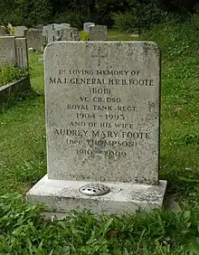 A granite headstone among other headstones