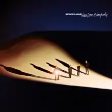 All four band members (from left: Caleb, Kieran, Peppa, Ashton) wearing black, standing on a sand dune lit up from the right, with Caleb holding a circular mirror reflecting light towards the camera.