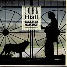 A black outline of Hiatt holding a guitar and a dog looking at one another