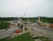 Construction equipment lines a highway overpass