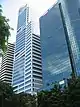 Ground-level view of a 40-storey building with a glass facade and rectangular cross section; three levels of windows recede inward at various points up the tower, and a spire is present on the roof.