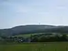 The Hohe Wurzel (with its TV tower) from the west,  in the foreground is (in the valley) Wambach, in the foreground is Bärstadt, on the extreme left is the Großer Feldberg