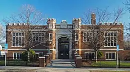 Hosmer Library, a dark brown brick building with parapets, in early spring