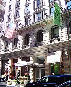 View of the Redbury New York as seen from across 30th Street. The facade is made of brick and stone, with large ground-story windows and doorways.