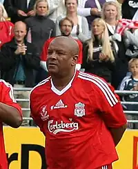 Middle-aged black man wearing a Liverpool football shirt