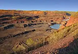 A miner poses near the edge of the pit. The pit is more than three miles long, two miles wide and 535 feet deep.