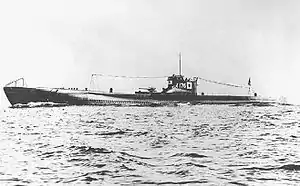 Large submarine running on the surface of the sea with a prominent deck gun and with radio mast raised