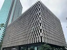 The IBM Building in Honolulu, seen from the corner. The building is covered in a concrete grid or lattice pattern.