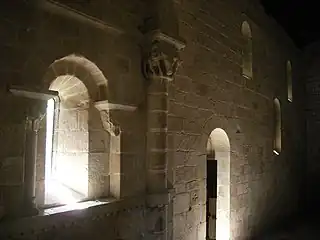 Interior of the church of São Pedro de Ferreira Monastery with small openings and carved capitals.