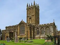 Elaborately ornamented stone building with square tower.