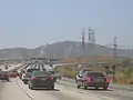 The HVDC power line in Los Angeles (shorter tower carrying two wires on the right). The power line crosses Interstate 5 near the interchange with Interstate 210 in Sylmar.