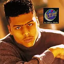 The cover features a black man wearing a grey sweater, sporting a hi-top fade and unibrow. On his left in a black square is the artist's name and album title.