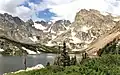 East aspect of Navajo Peak (left, pyramid shape), Apache Peak (center), and Shoshoni Peak (right). Lake Isabelle to left.