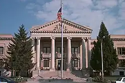 Front of two-story building with columns, with a flagpole in front