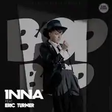 Inna wearing the officer outfit from the music video while leaning on the words "BOP BOP" placed on a black backdrop.