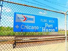 Blue sign attached to chain-link fence