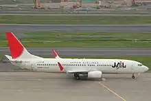 A Boeing 737 aircraft on the runway, facing right