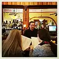 Jack, a bartender, with patrons at the bar