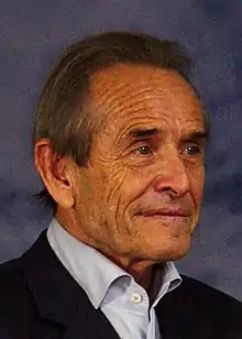 Jacky Ickx looking to the right of the camera in formal clothing