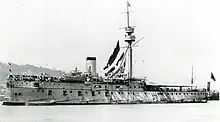 A large warship seen from the prow, racing forward through the sea