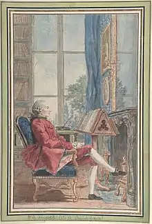 Man sitting in chair in front of a book stand