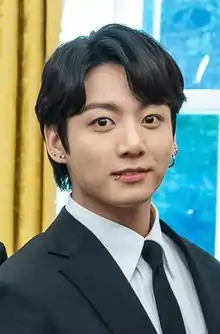 A close-up shot of Jungkook looking directly at the camera.