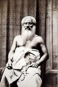 A black-and-white photograph of Joeli Bulu as an elder. He is shirtless with a cloth around his abdomen, has white hair and a large beard.