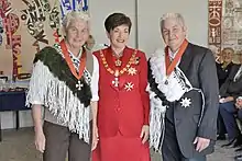 three people in formal clothes pose for the camera