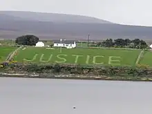 Aerial view of the word "Justice" mowed on a hayfield