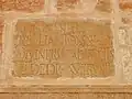 Close view of one of the Roman stones (with Latin inscriptions) reused at the base of the minaret