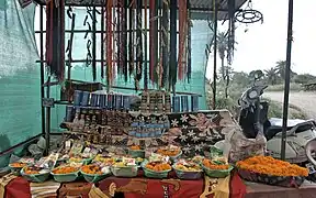 A non-government vendor outside the temple, selling liquor, flowers and books