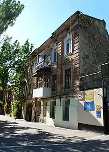 Three-storey building on a tree-lined city street