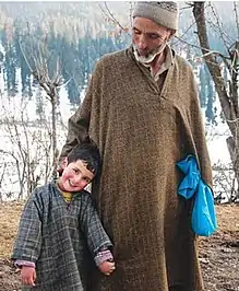 Elderly Kashmiri man with his grandson in traditional pheran