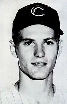 A black and white portrait photograph of a baseball player wearing a dark cap with a "C" on the center