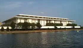 The Kennedy Center (a low-rise white building) as seen from the Potomac River