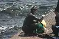 After emerging from the sea, haenyeo selling her gathered seafood to people on the coast of Jeju.