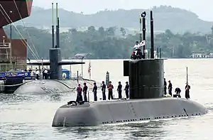 The Korean submarine Choi Museon makes its way past the United States Navy's USS Helena (Los Angeles class) and into the Sembawang port facilities in Singapore during Exercise PACIFIC REACH 2000.