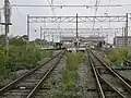 A view of the platforms and tracks. The train is standing on track 3 which is a siding. To the right, some sidings can be seen between the island platform and the station building.